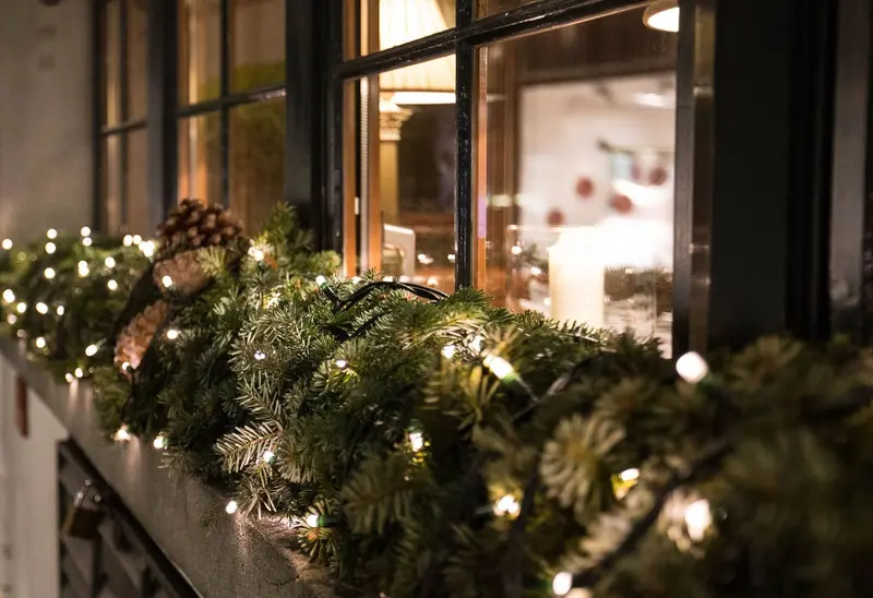Lit evergreen garland along a window ledge